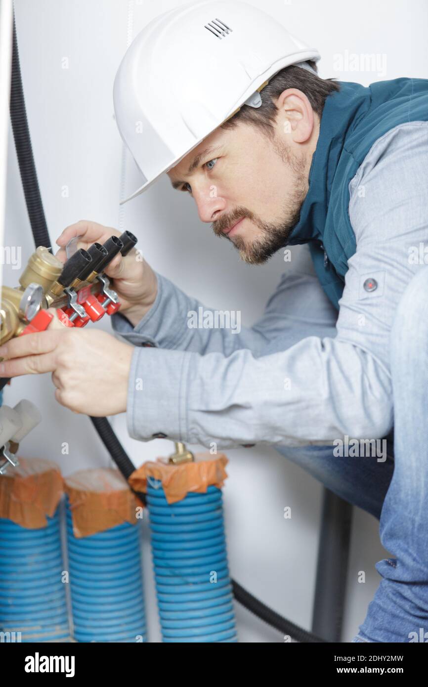 plumber installing and mounting water equipment Stock Photo Alamy