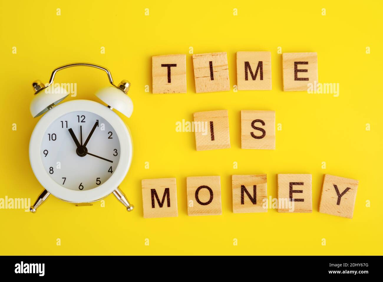 Text time is money concept with alarm clock and wooden block cubes Stock Photo