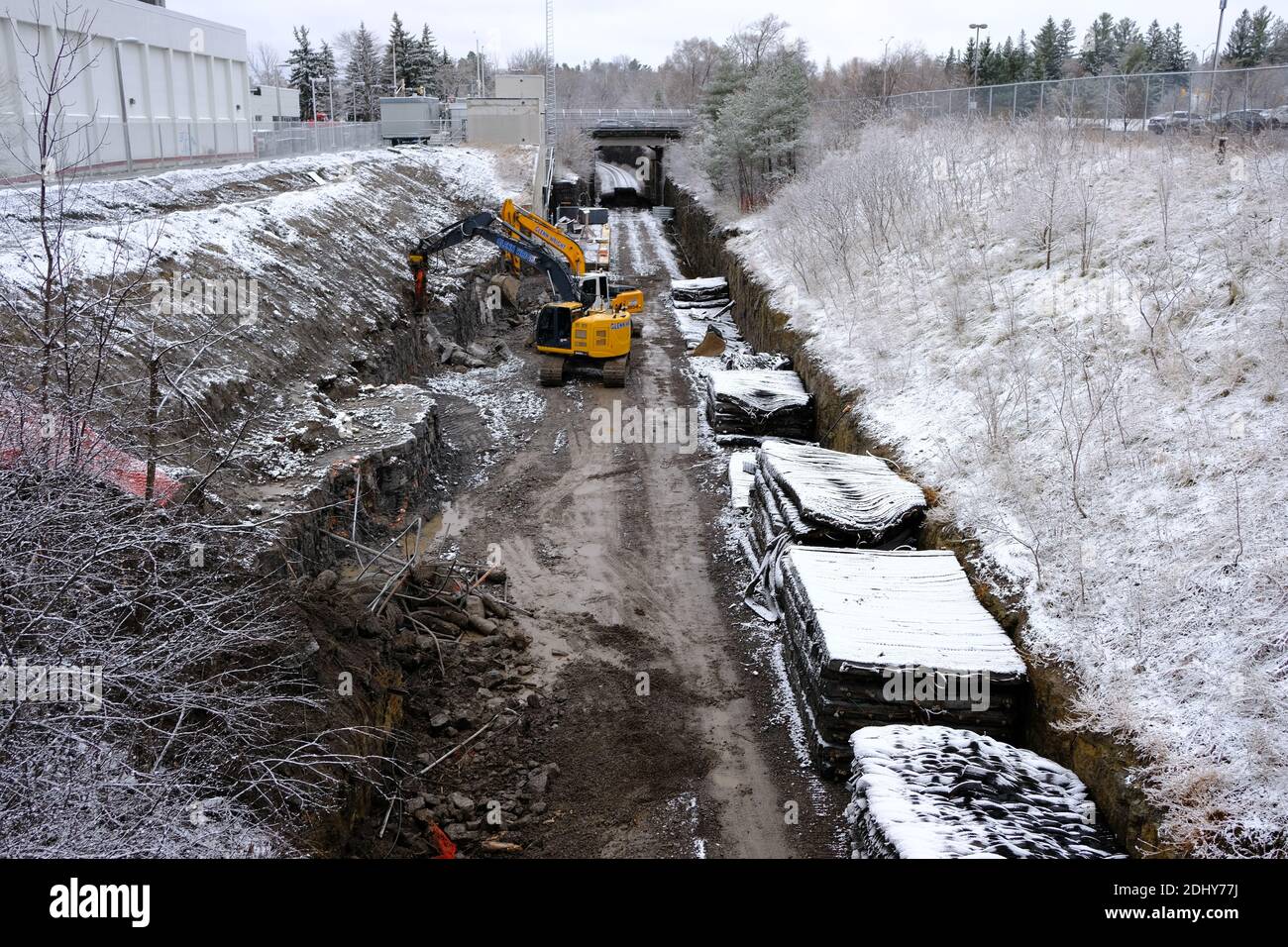 Under ballast mats and a digger widening the tracks for the Trillium line light rail upgrade/expansion at Carling Station, Ottawa, Ontario, Canada. Stock Photo