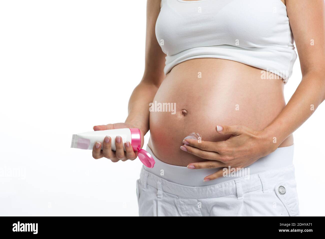 Schwangere Frau cremt ihren Bauch ein Stock Photo