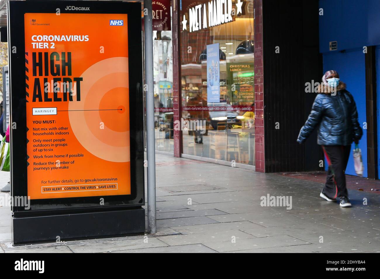 London, UK. 10th Dec, 2020. A woman wearing a face mask walks past a COIVD-19 public information campaign digital poster on display in London. Credit: Dinendra Haria/SOPA Images/ZUMA Wire/Alamy Live News Stock Photo
