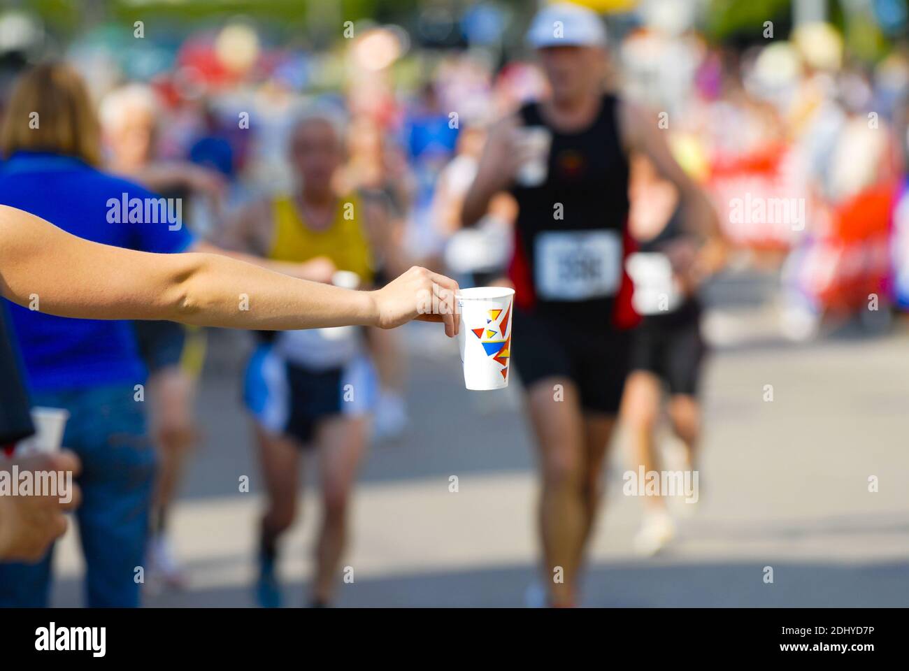 Trinken beim Jogging, Zuschauer reichen dem läufer Trinkbecher Stock Photo
