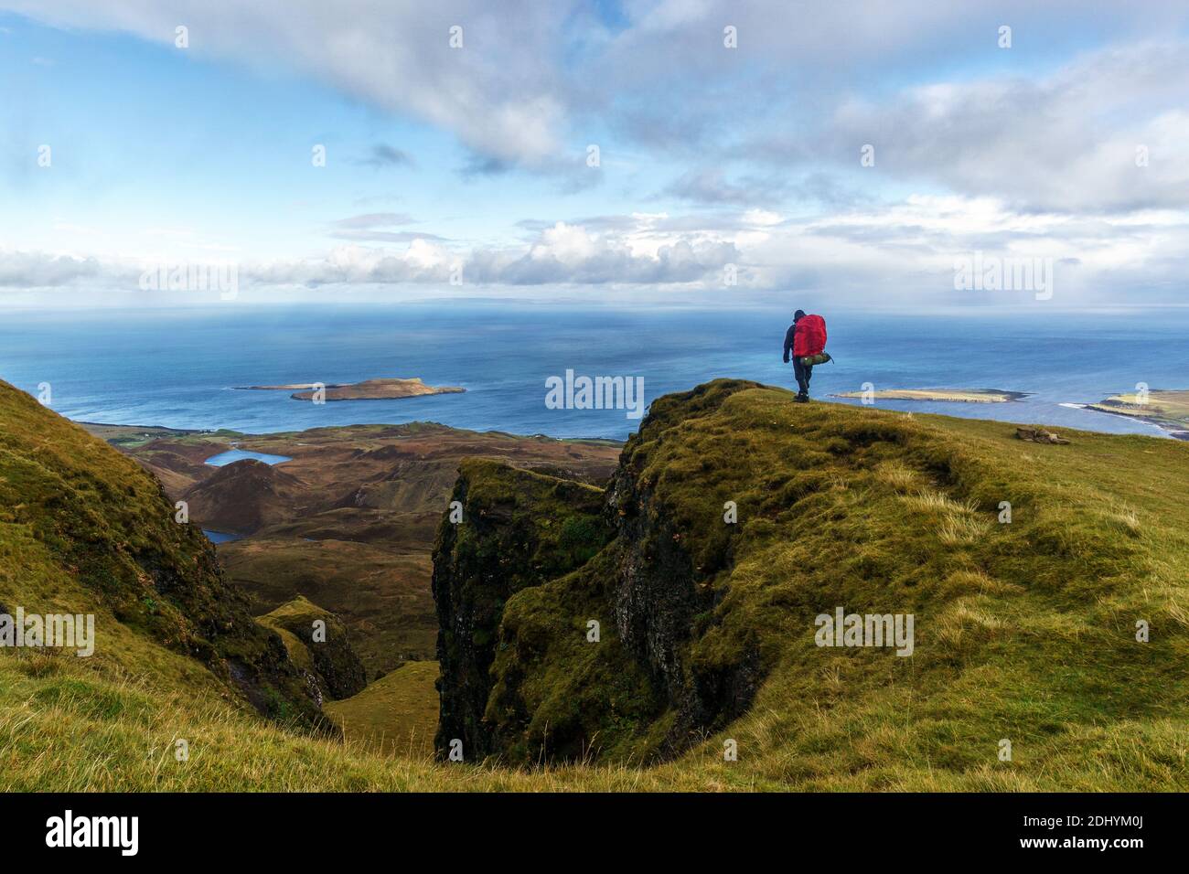 man standing on the edge of a cliff watching at the sea on isle of Skye in the Quiraing, Scotland Stock Photo