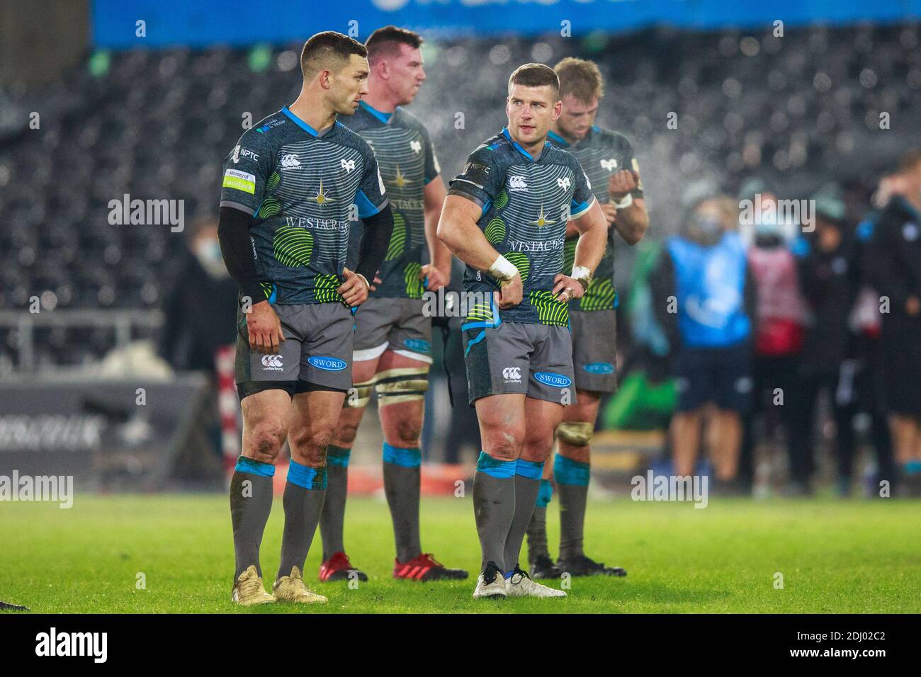 Swansea, Wales, UK. 12 December, 2020. Ospreys right wing George North and Ospreys replacement Scott Williams during the Ospreys v Castres Olympique European Rugby Challenge Cup Match. Credit: Gruffydd Thomas/Alamy Live News Stock Photo