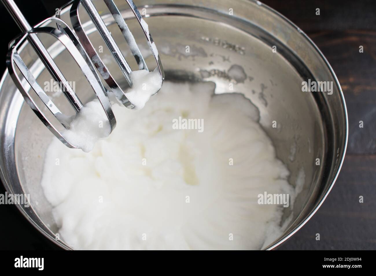 Beating Egg Whites to Make Meringue: Egg whites that have been beaten in a stand mixer until they are fluffy Stock Photo