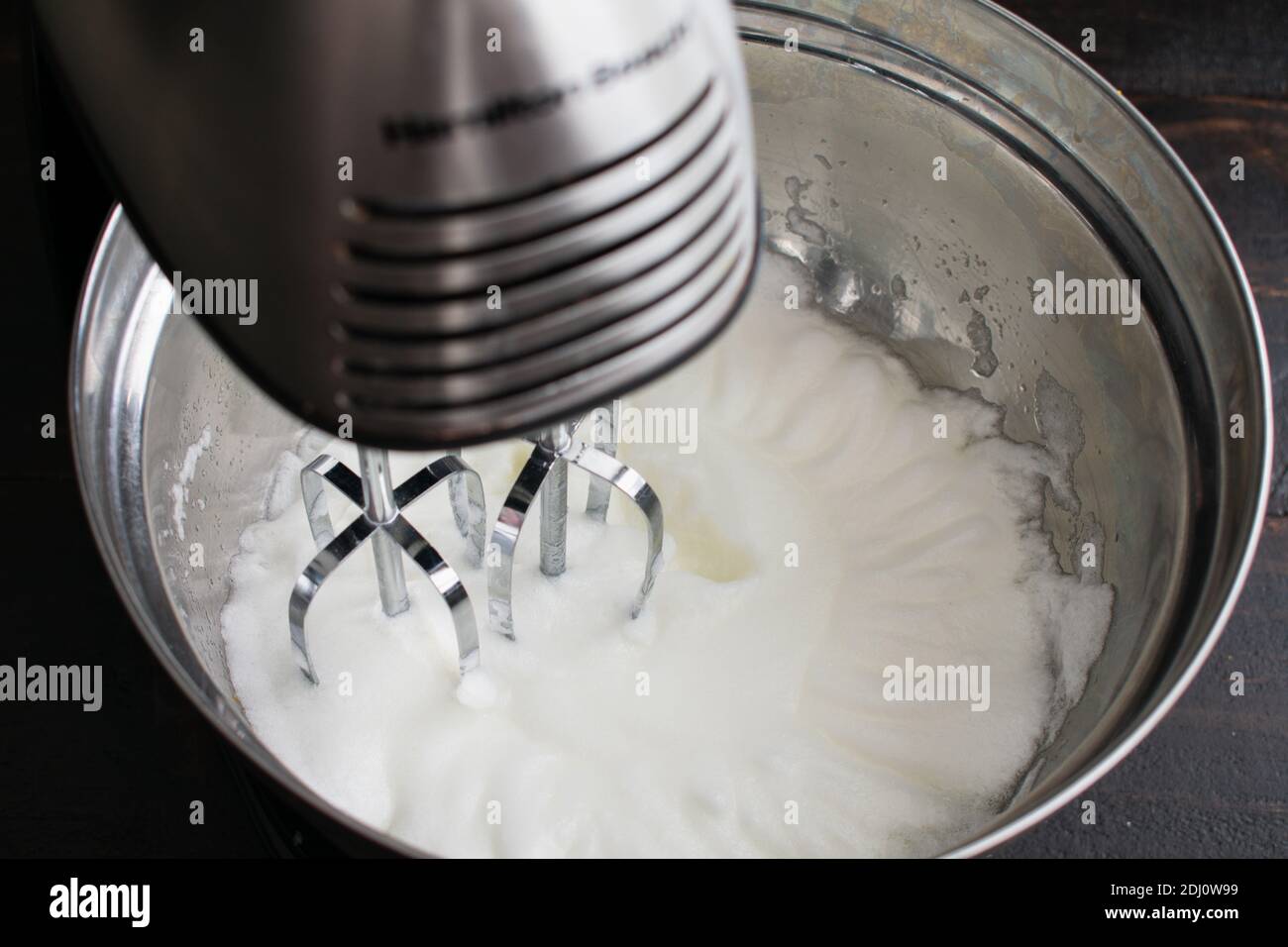 Beating Egg Whites to Make Meringue: Egg whites that have been beaten in a stand mixer until they are fluffy Stock Photo