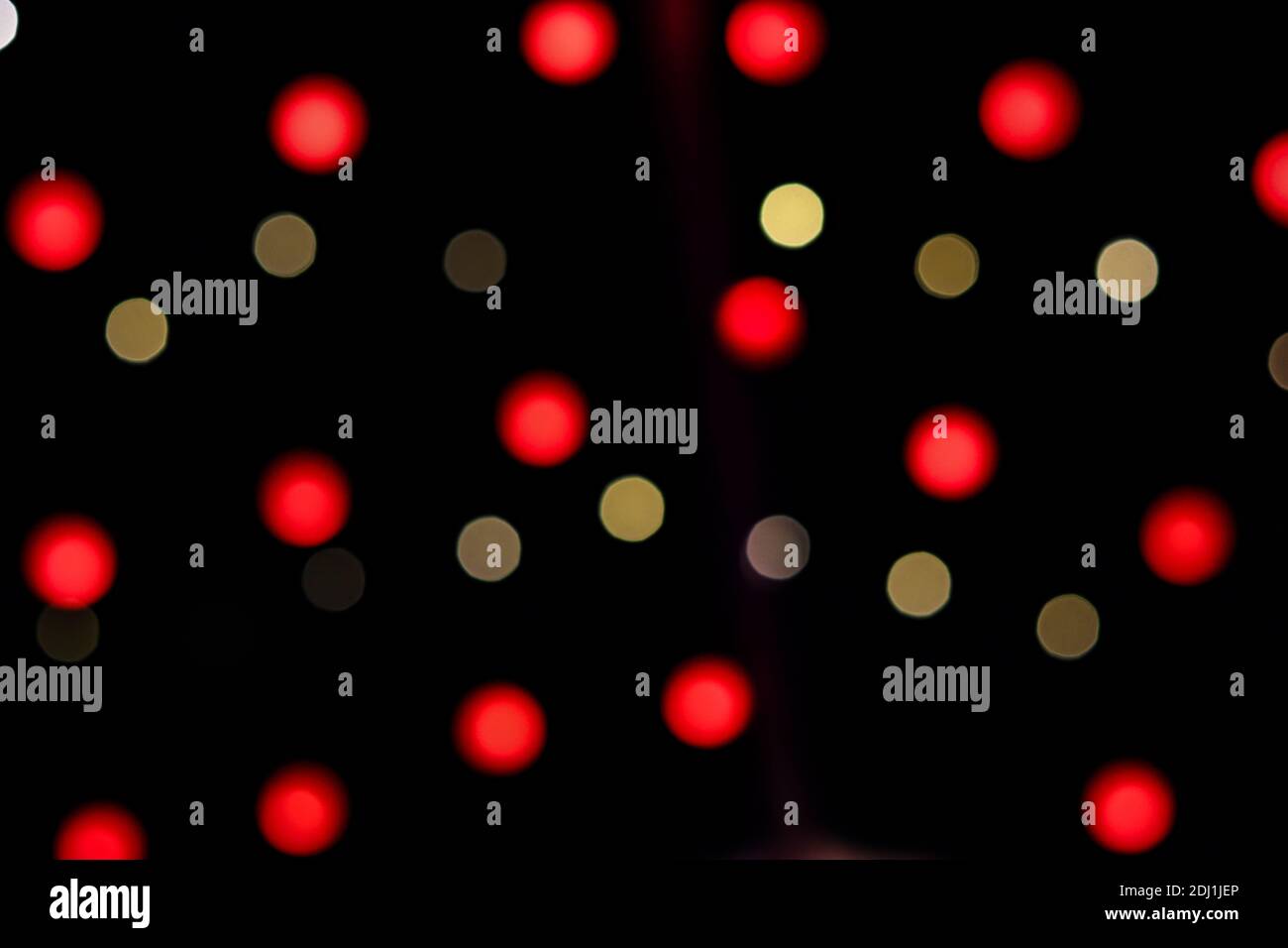 Bokeh yellow and red Christmas lights abstract night photo on black