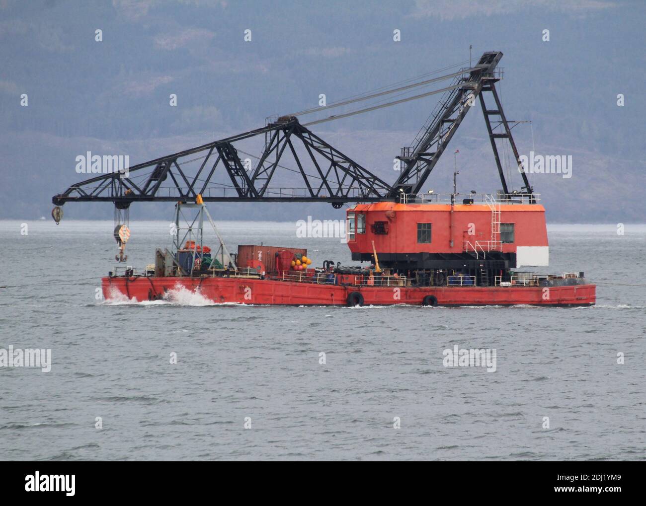 A heavy lift crane barge (BD6072) operated by Keynvor MorLift Ltd, being towed by the tug Handfast, on an outbound journey on the Firth of Clyde. Stock Photo