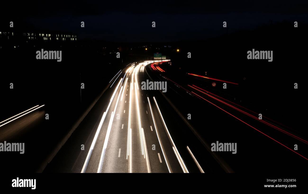 Light trail of cars on a highway during the morning. Spun vehicles on the road as seen from a bridge. Lightpainting scene. Stock Photo