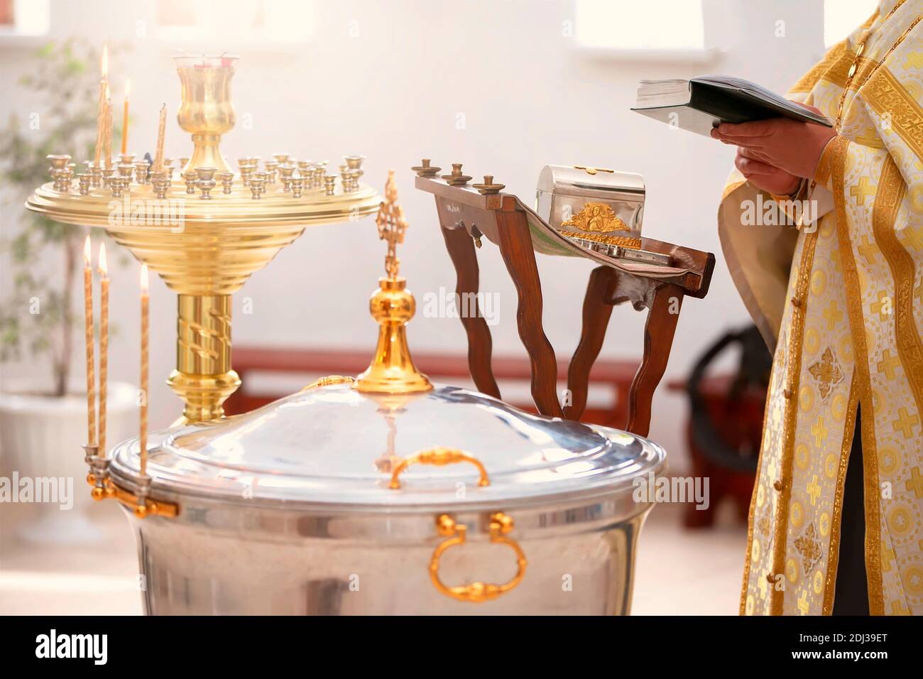Baptism rite. Font for Orthodox baptism and the priest reads a prayer