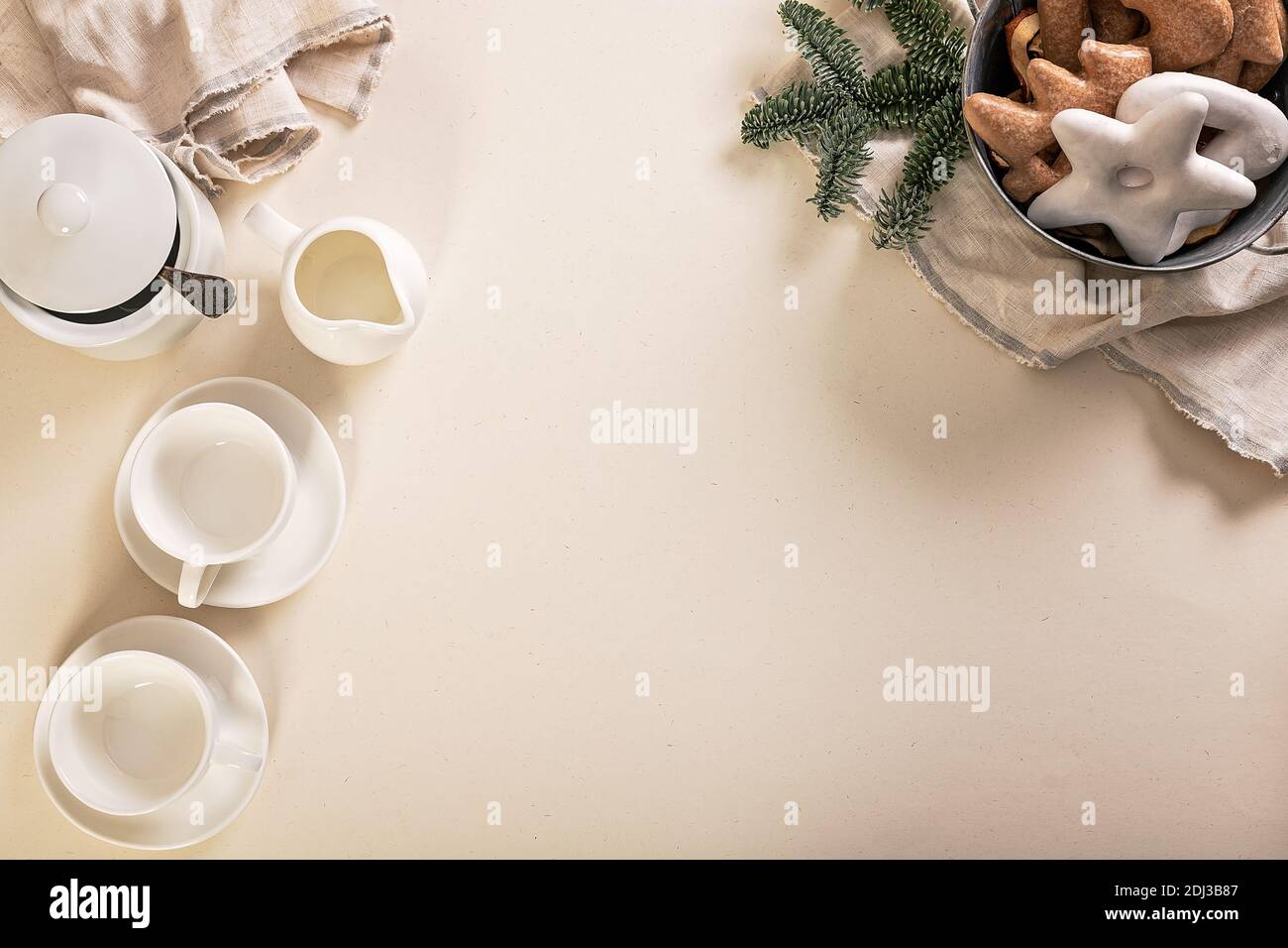 Christmas food flat lay. White coffee cups, gravy boat, basket with cookies and spruce branches on a beige background. Top view. Copy space Stock Photo