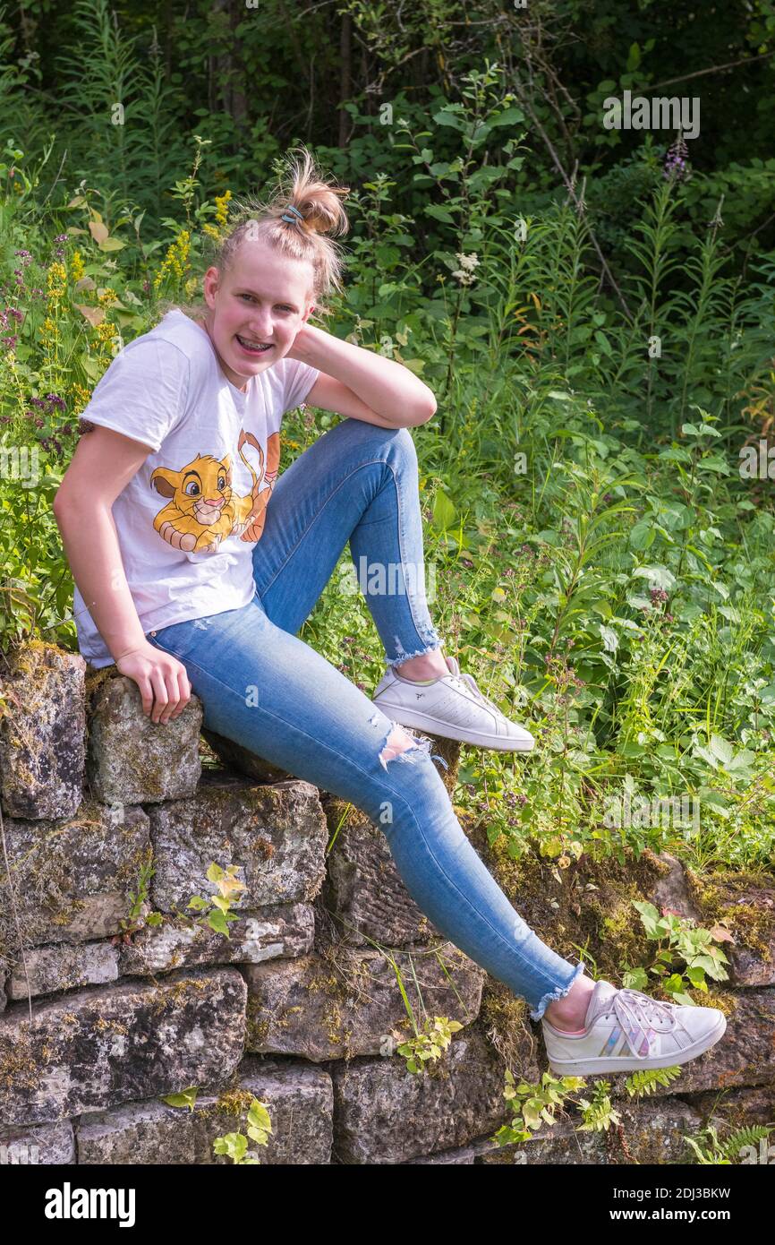 Teenager, young woman sitting on the wall, Baden-Wuerttemberg, Germany Stock Photo