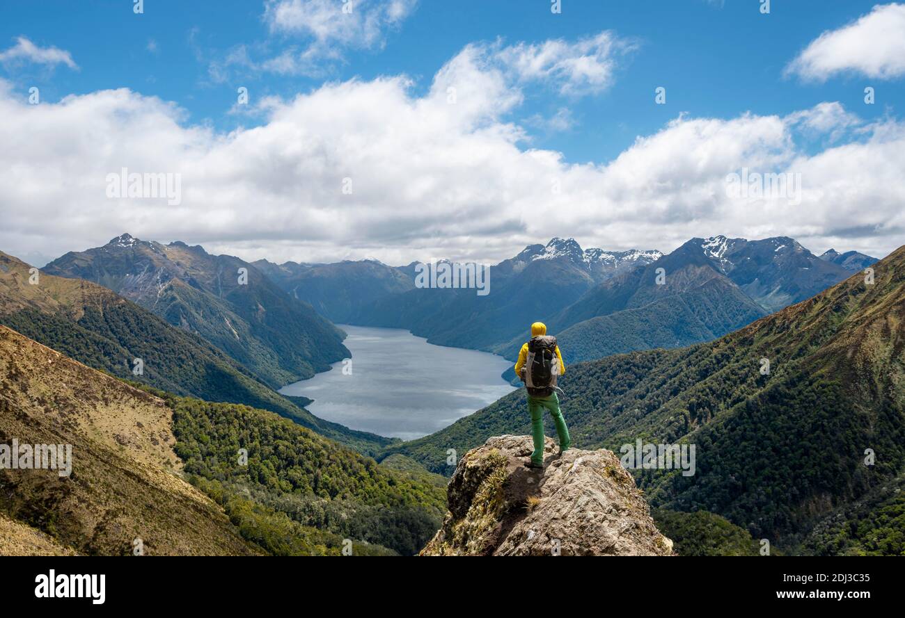 Mountaineer, hiker looking into the distance, view of the South Fiord of Lake Te Anau, Murchison Mountains and Southern Alps in the background, on Stock Photo