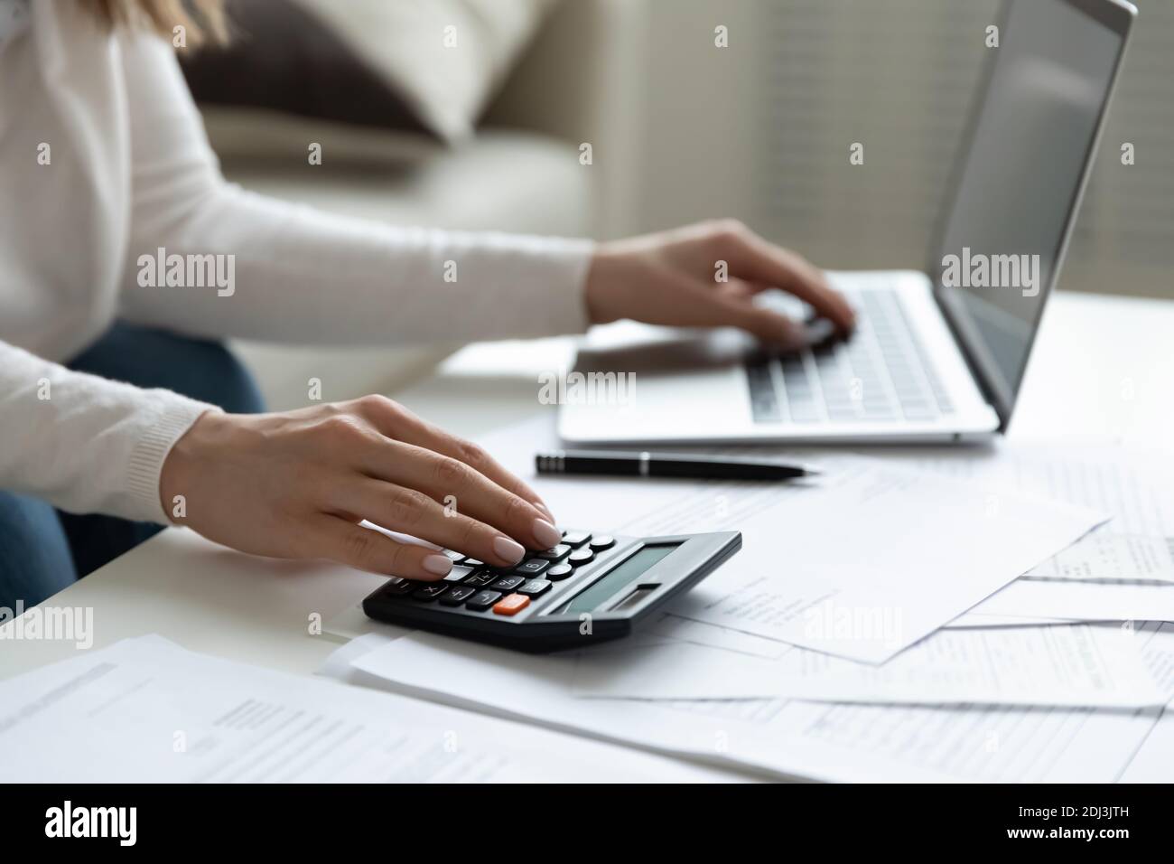 Close up young woman using calculator and laptop, checking bills Stock ...