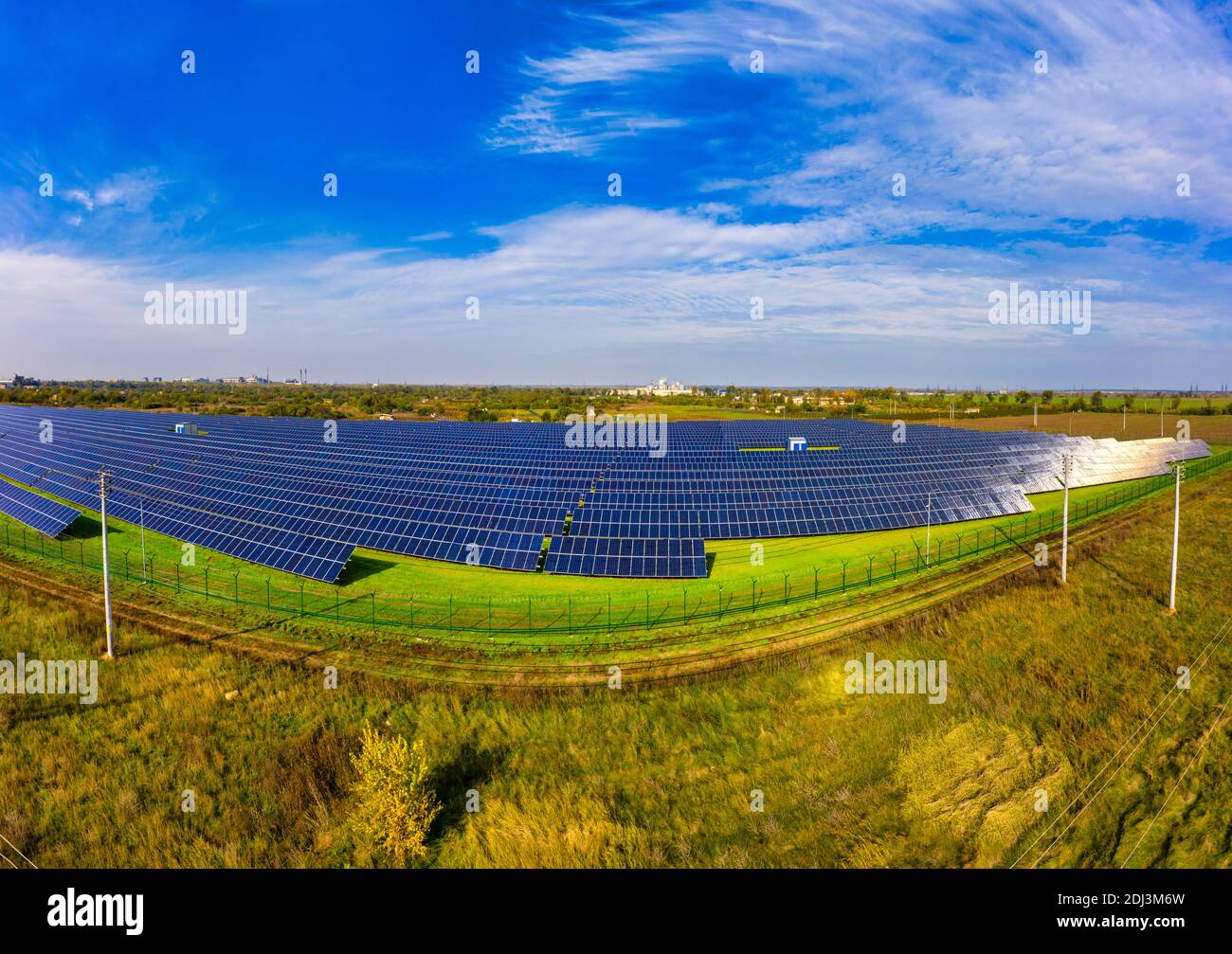 Huge solar power plant to use solar energy in a picturesque green field in Ukraine. Aerial
