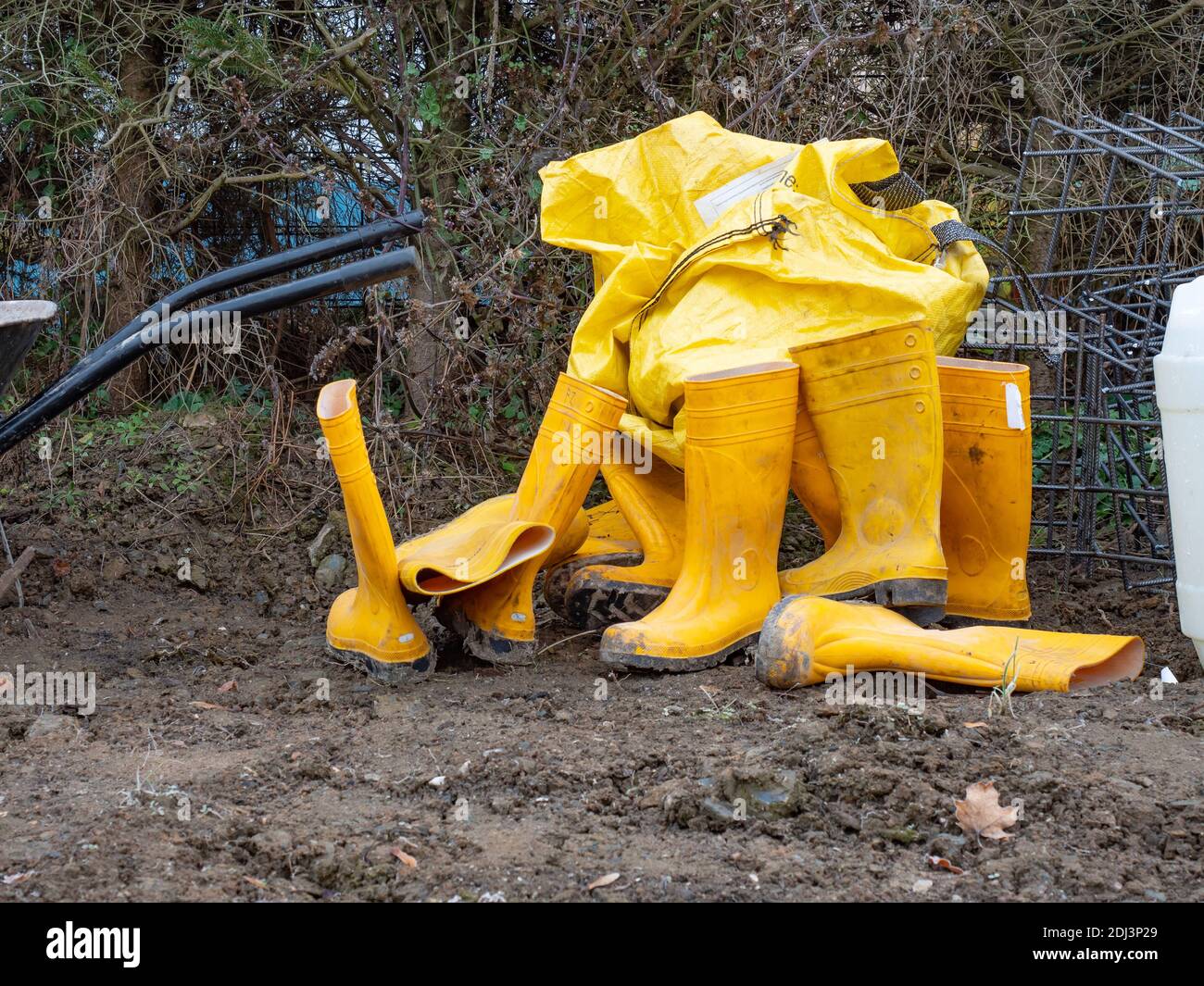 Hard working yellow rubber boots covered in dirt. Wet clay boots for