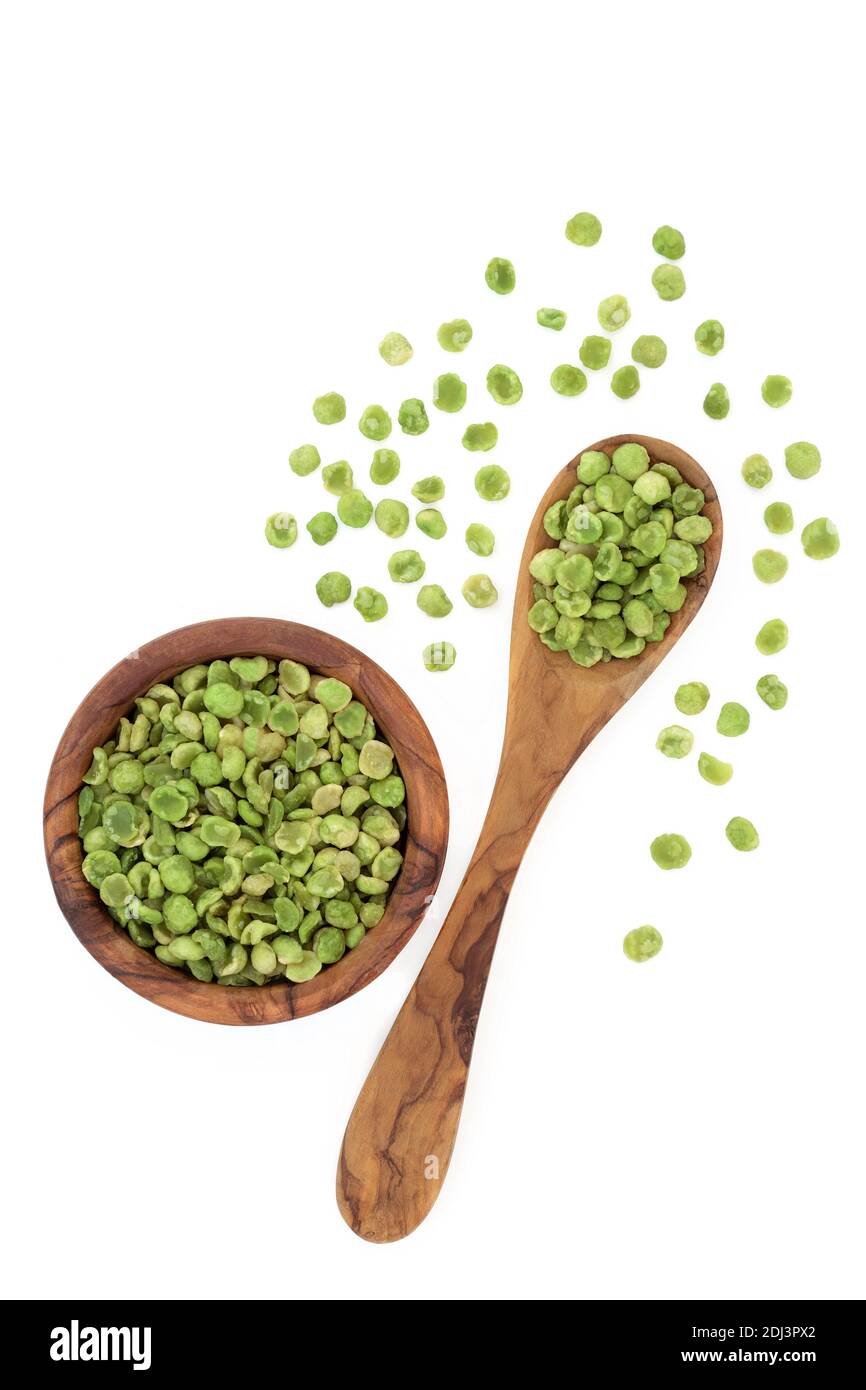 Roasted green peas healthy high protein snack food in an olive wood spoon &  bowl on white background. Also high in dietary, fibre, protein, vitamins  Stock Photo - Alamy