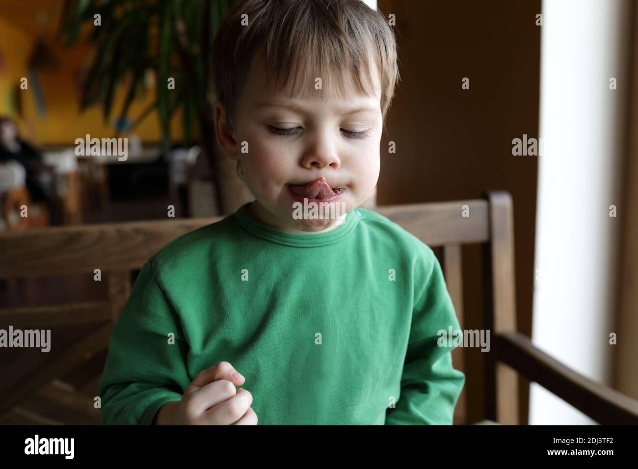 Child with tongue out in a cafe Stock Photo Alamy