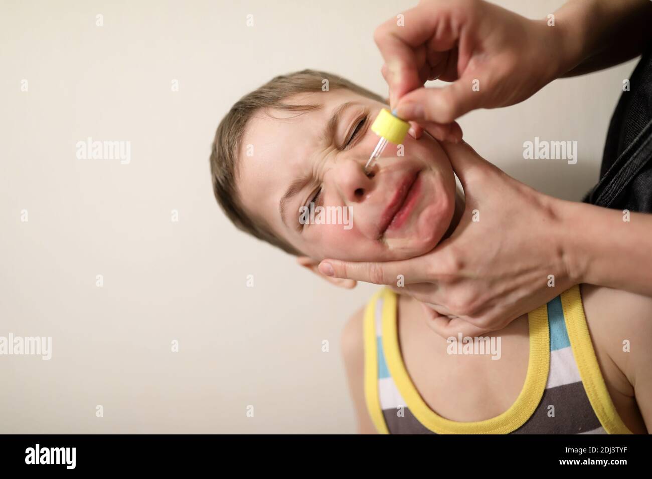 Person treats the child runny nose at home Stock Photo