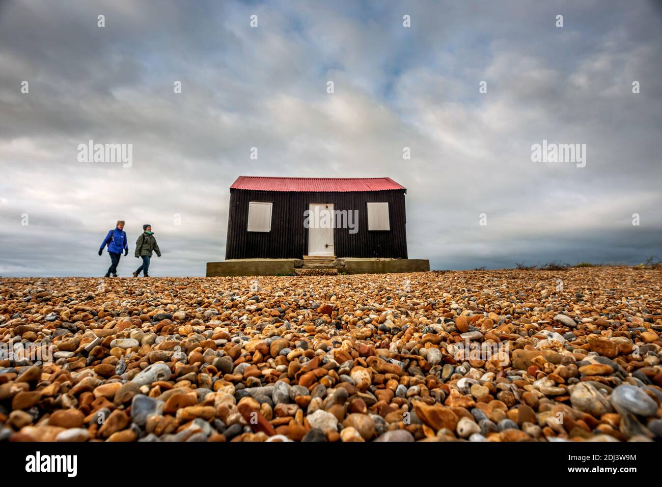 Rye Harbour, December 12th 2020: Storm clouds gather over the iconic red roofed hut that sits on the shingle beach at the entrance to Rye Harbour Credit: Andrew Hasson/Alamy Live News Stock Photo