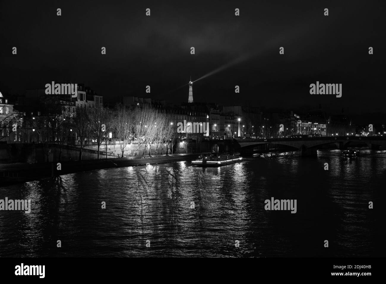 PARIS, FRANCE - DECEMBER 2, 2018:  Night view of illuminated Eiffel tower and Seine river landscape. Black white photo Stock Photo