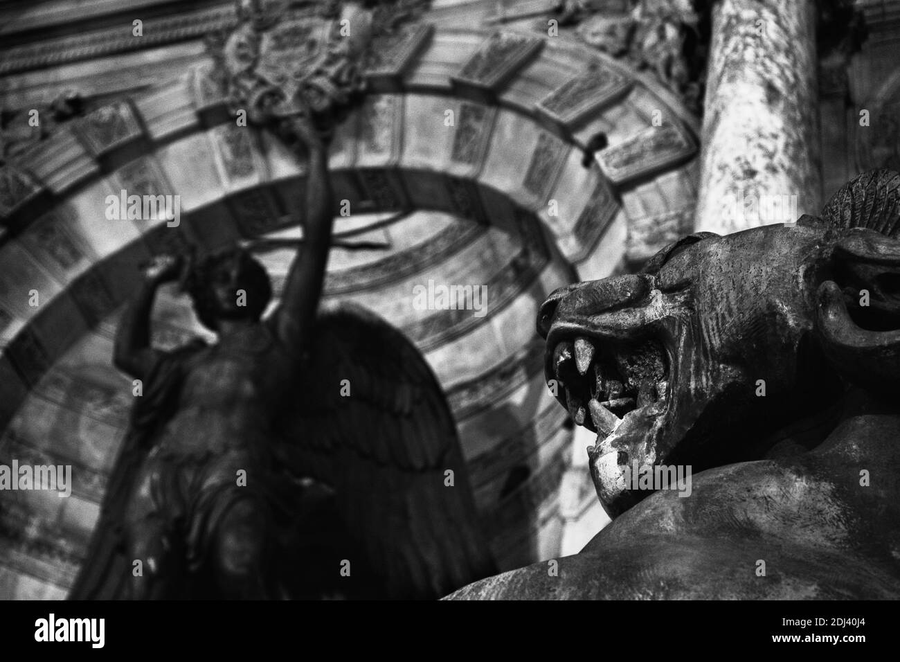 Night Fight. Saint-Michel fountain at Paris, France. Dragon and Archangel Michael at background slaying the devil. Black and white photo. Stock Photo