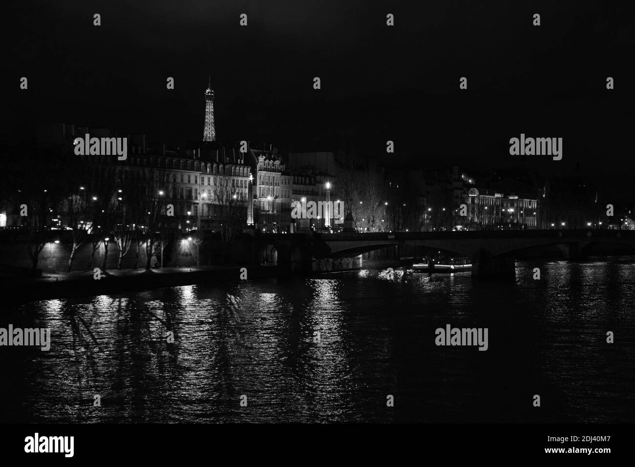 PARIS, FRANCE - DECEMBER 2, 2018:  Night view of illuminated Eiffel tower and Seine river landscape. Black white photo Stock Photo