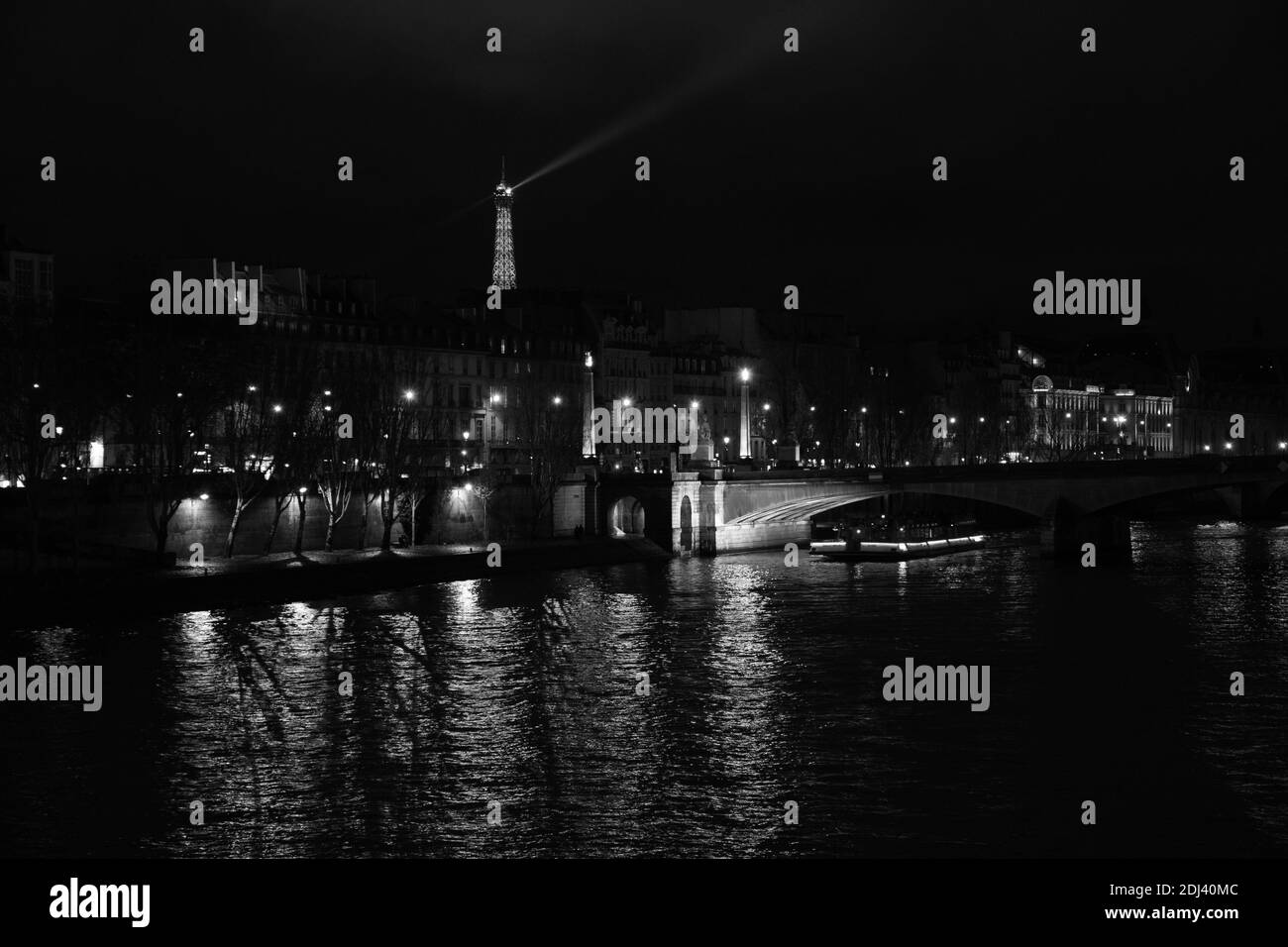 PARIS, FRANCE - DECEMBER 2, 2018:  Night view of illuminated Eiffel tower and Seine river landscape. Black white photo Stock Photo