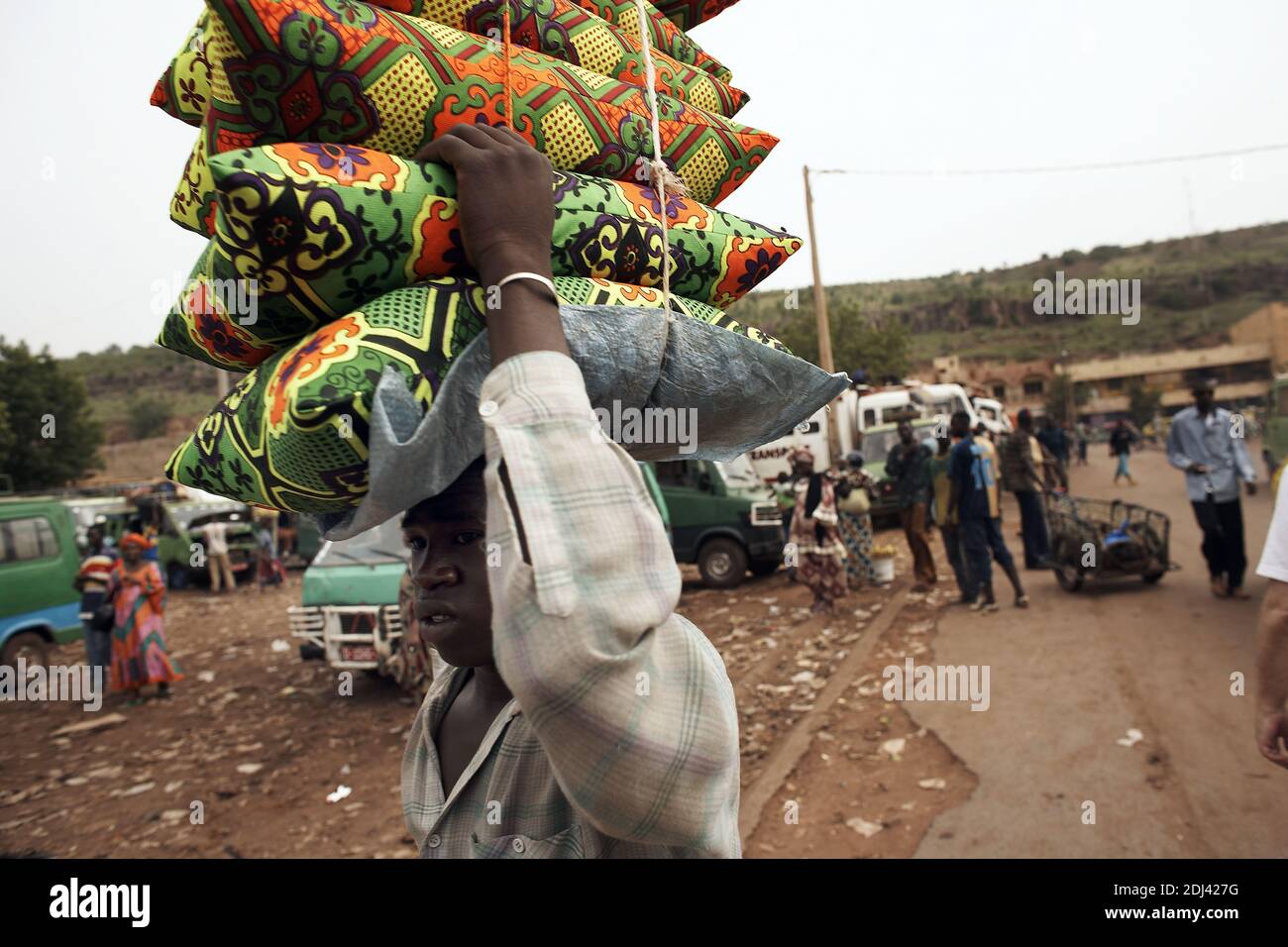 Africa /Mali/Bamako/Bamako main market (Grand Marche) .Marchant carrying pilows on his head . Stock Photo