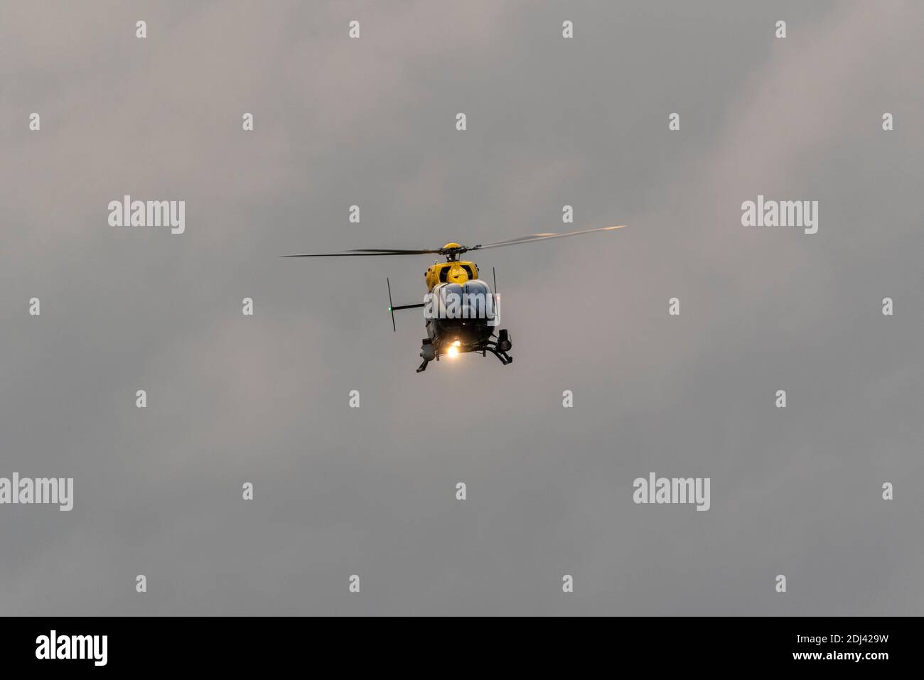 Police helicopter against dark threatening sky over London Southend Airport, Essex, UK, on cold December day. Crew training. Big, heavy cloud sky Stock Photo