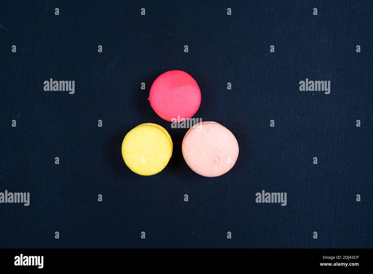 Colourful stack of macaroons isolated on plain black background. Copyspace Stock Photo