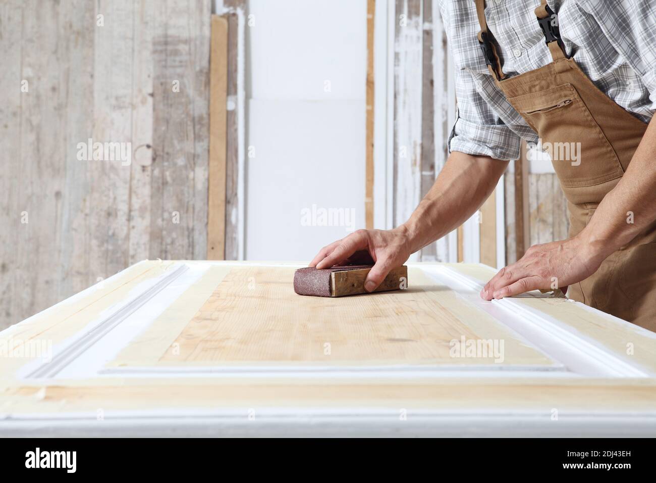 Male carpenter working the wood in carpentry workshop sanding a