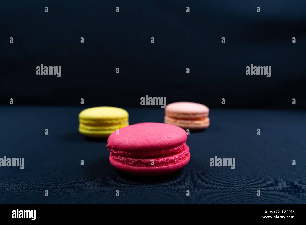 Colourful stack of macaroons isolated on plain black background, Copyspace Stock Photo