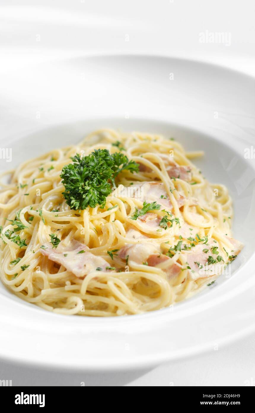 spaghetti carbonara italian pasta dish on white table background Stock Photo