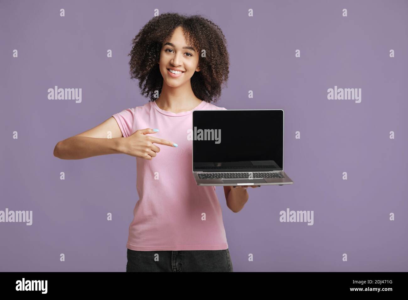 Featured website, store and online advertising. Cheerful woman points finger at laptop with blank screen Stock Photo