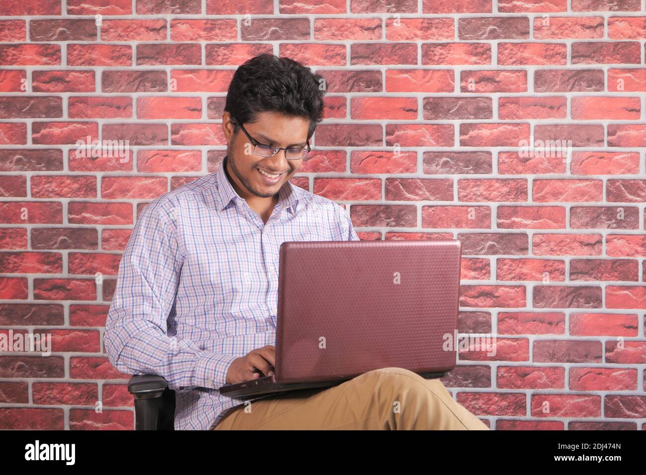 young man sitting on chair using laptop  Stock Photo