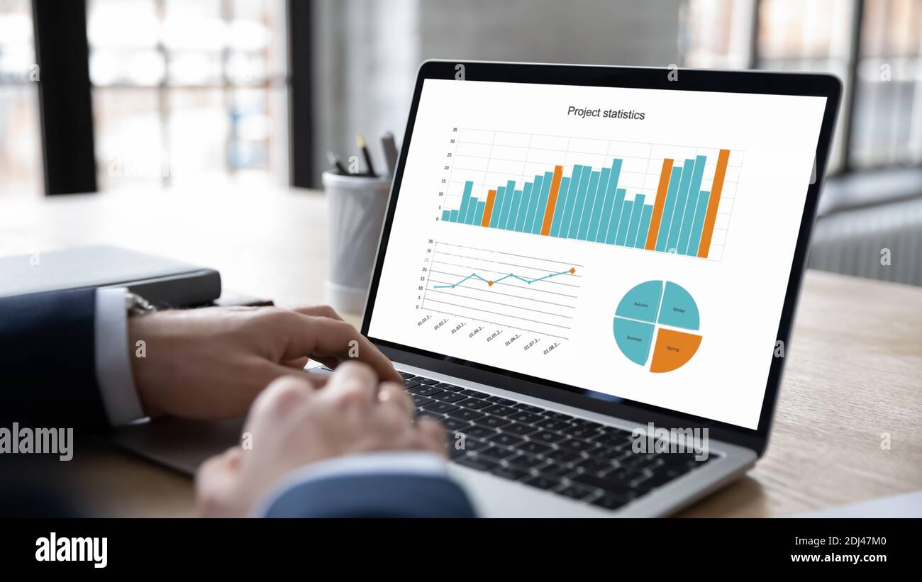 Close up businessman working with project statistics, using laptop Stock Photo
