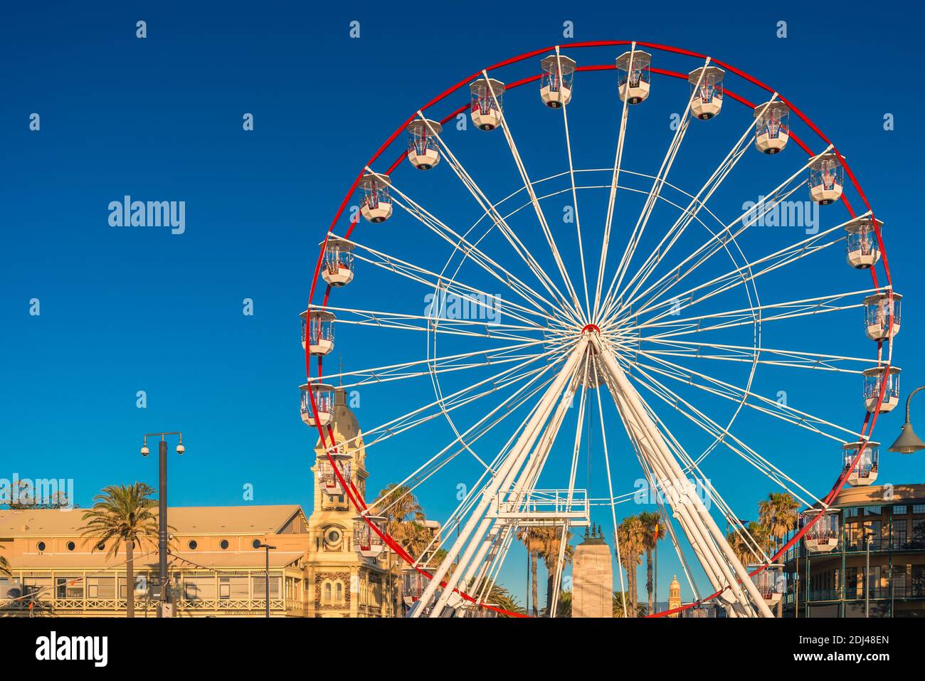 Adelaide, South Australia - January 12, 2019: Glenelg Giant Ferris Wheel at Moseley Square viewed from the jetty at sunset time Stock Photo
