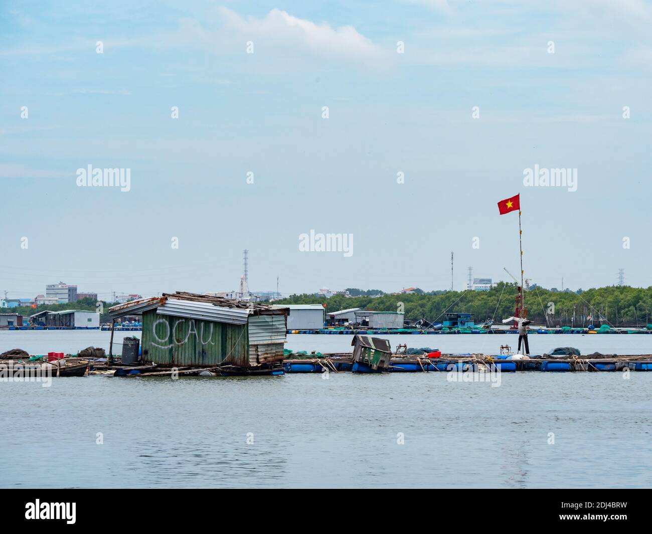 Fish farms on Dinh River near Vung Tau in the Bang Ria-Vung Tau Province of South Vietnam. Industrial areas in the background. Stock Photo