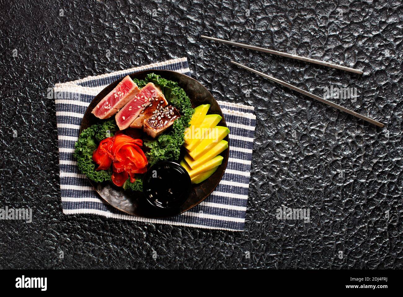 Tuna steak with avocado closeup on a plate. Red steak tuna grilled bbq