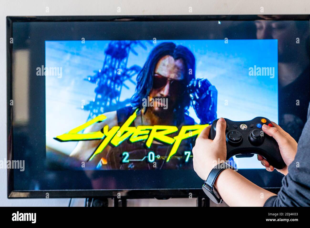 Woman holding a xbox controller and playing popular video game Cyberpunk  2077 on a television and PC Stock Photo - Alamy