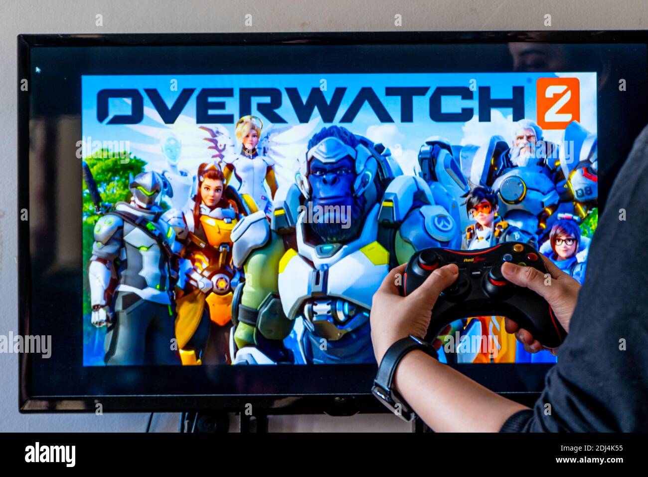 Woman Holding A Generic Controller And Playing Popular Video Game Overwatchon A Television And Pc Stock Photo Alamy
