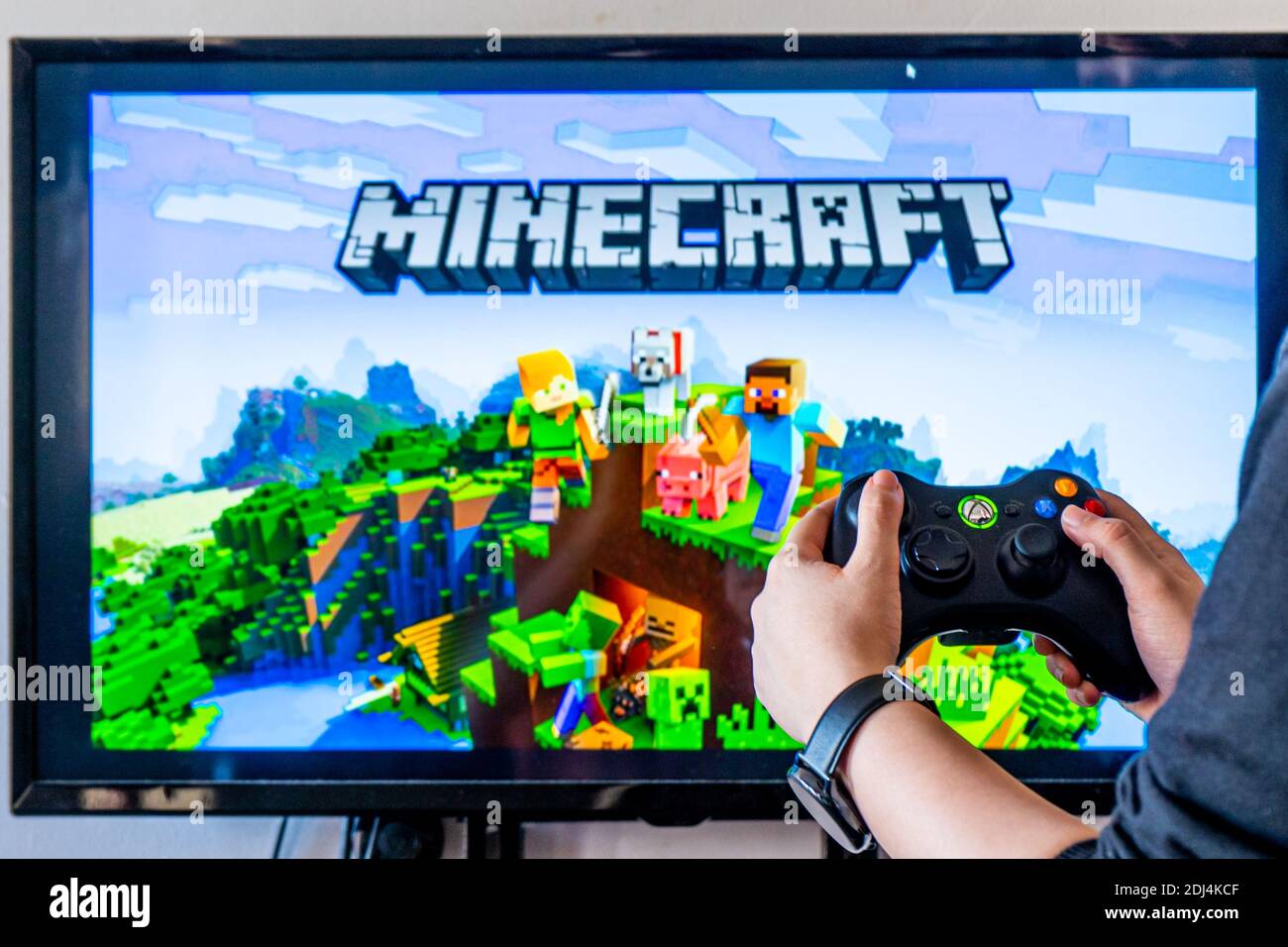 Woman holding a xbox controller and playing popular video game minecraft on  a television and PC Stock Photo - Alamy