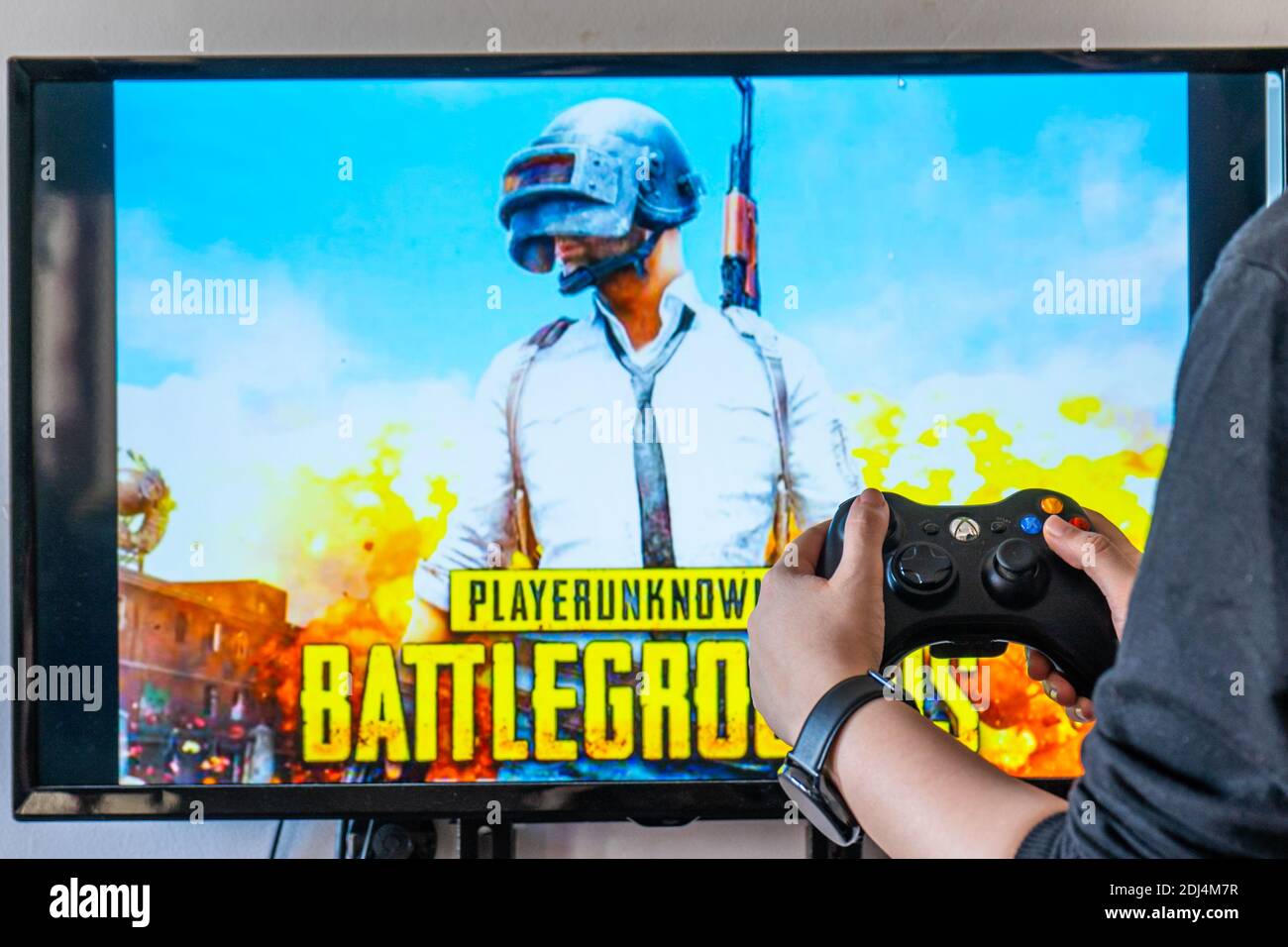 Woman holding a xbox controller and playing popular video game Player  Unknown's battlegrounds PUBG on a television and PC Stock Photo - Alamy