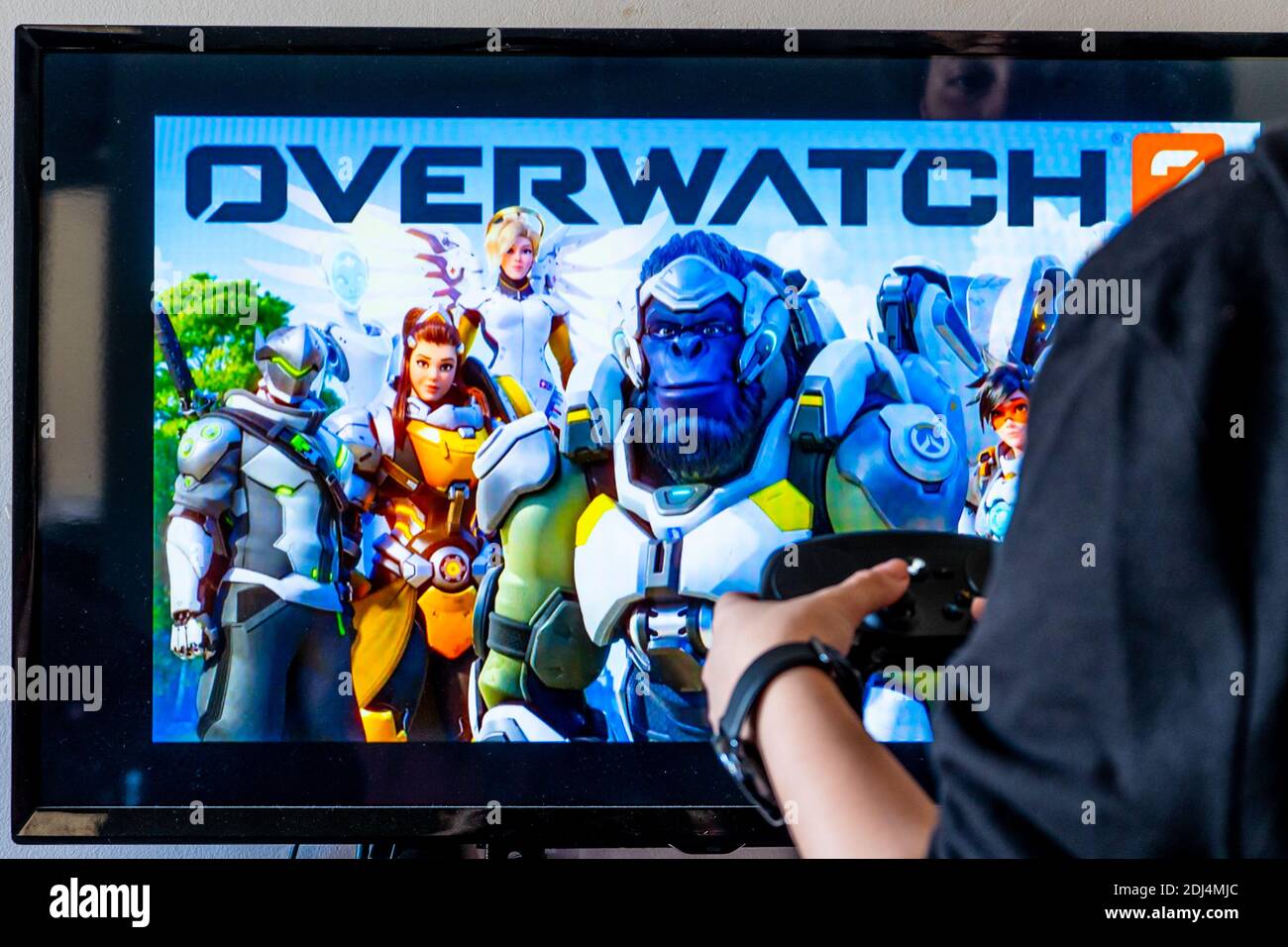 Woman Holding A Steam Controller And Playing Popular Video Game Overwatch On A Television And Pc Stock Photo Alamy