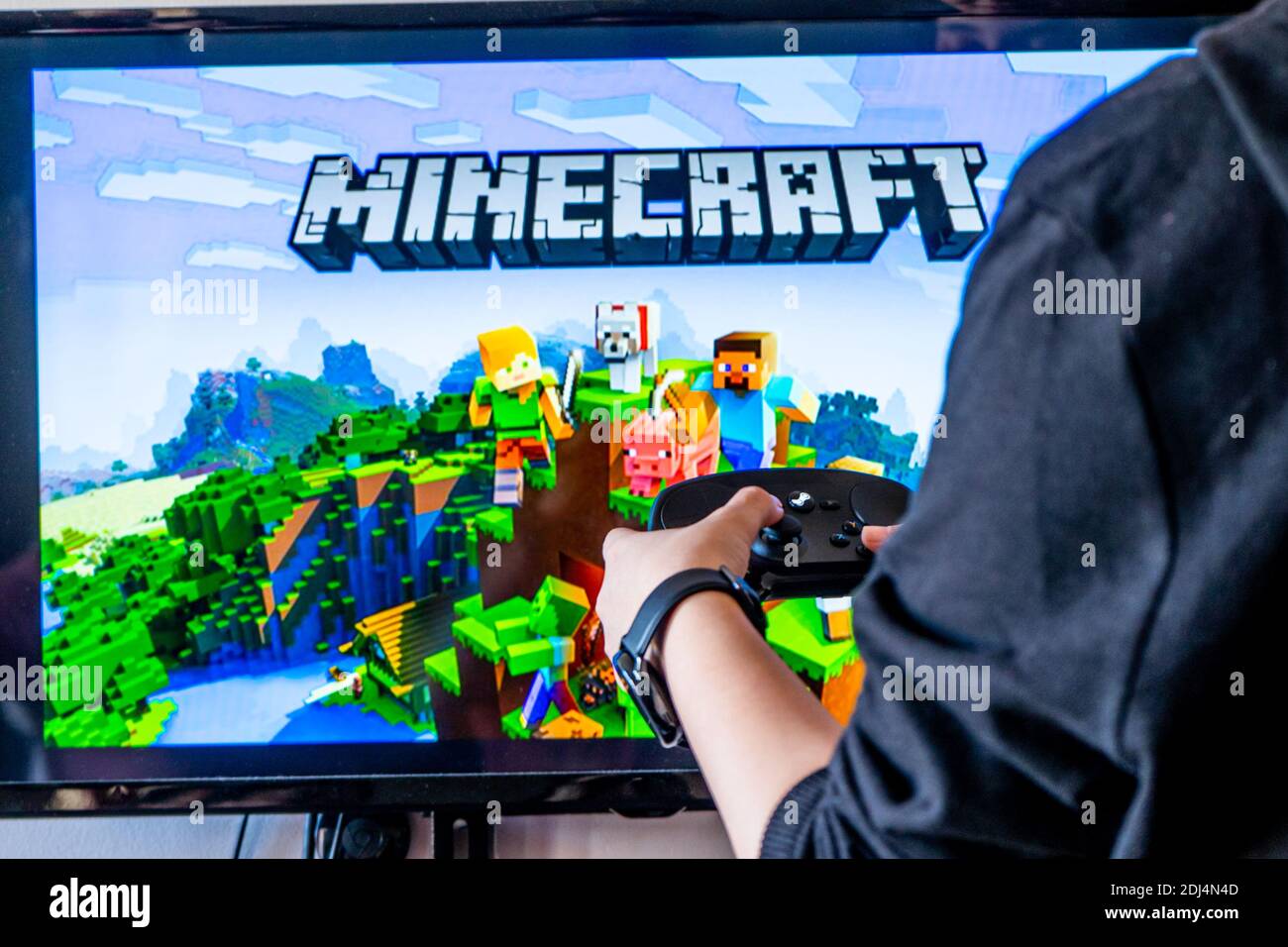 Woman Holding A Steam Controller And Playing Popular Video Game Minecraft On A Television And Pc Stock Photo Alamy