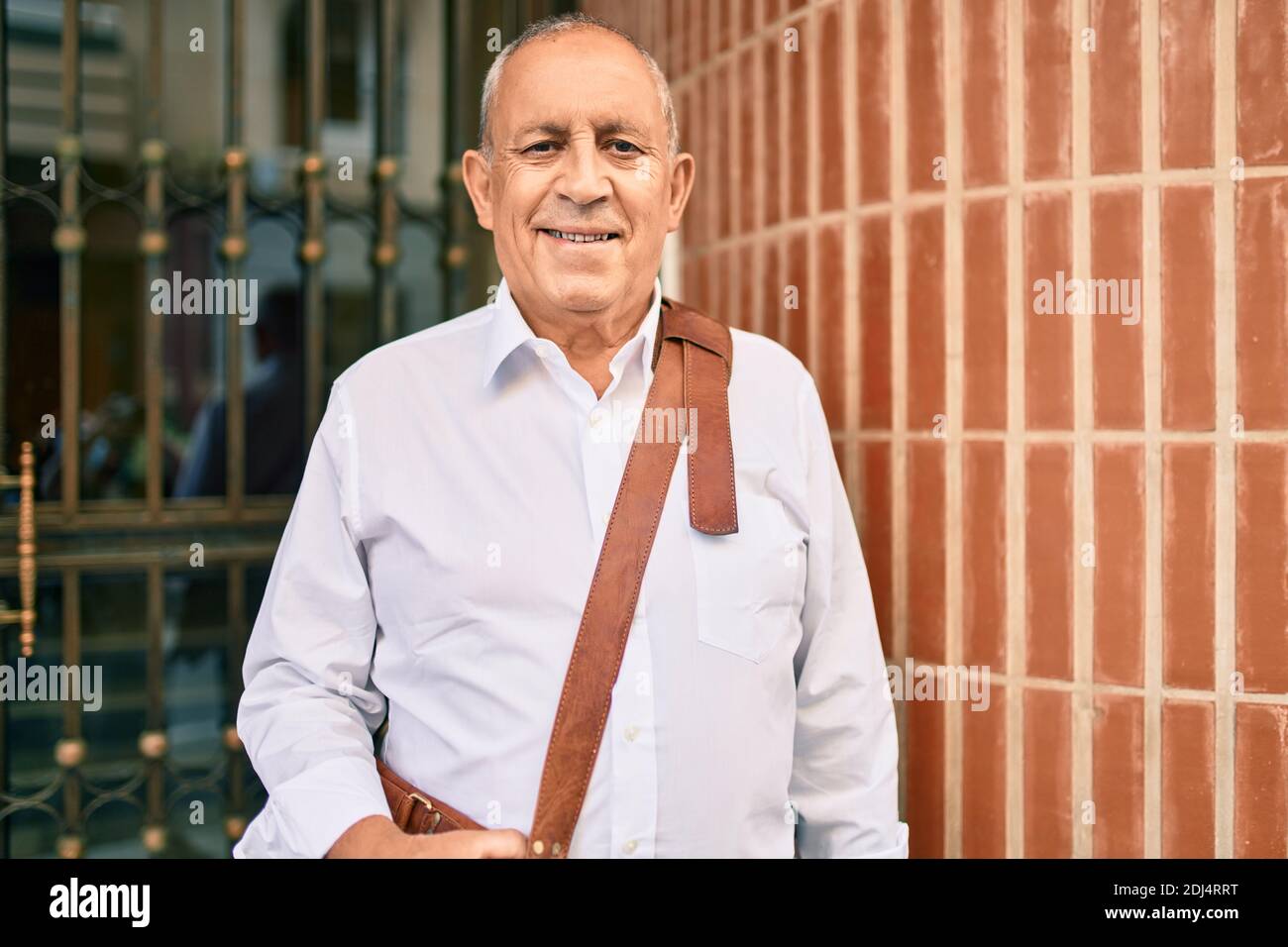 Senior businessman smiling happy walking at the city Stock Photo - Alamy
