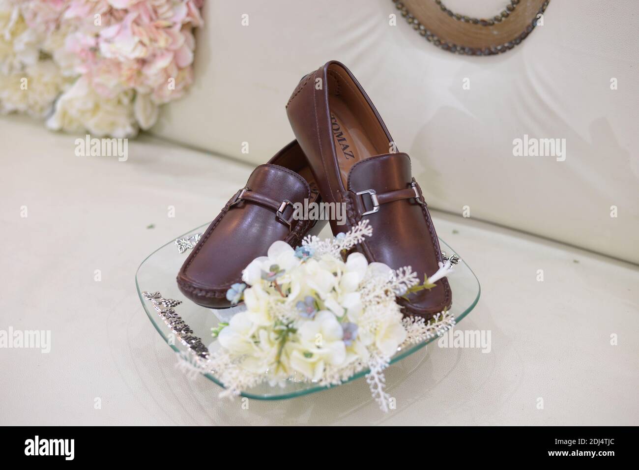 Wilmington, Delaware, U.S.A - December 1, 2020 - A pair of Tomaz brown leather shoes decorated with white hydrangea flowers for wedding gift Stock Photo