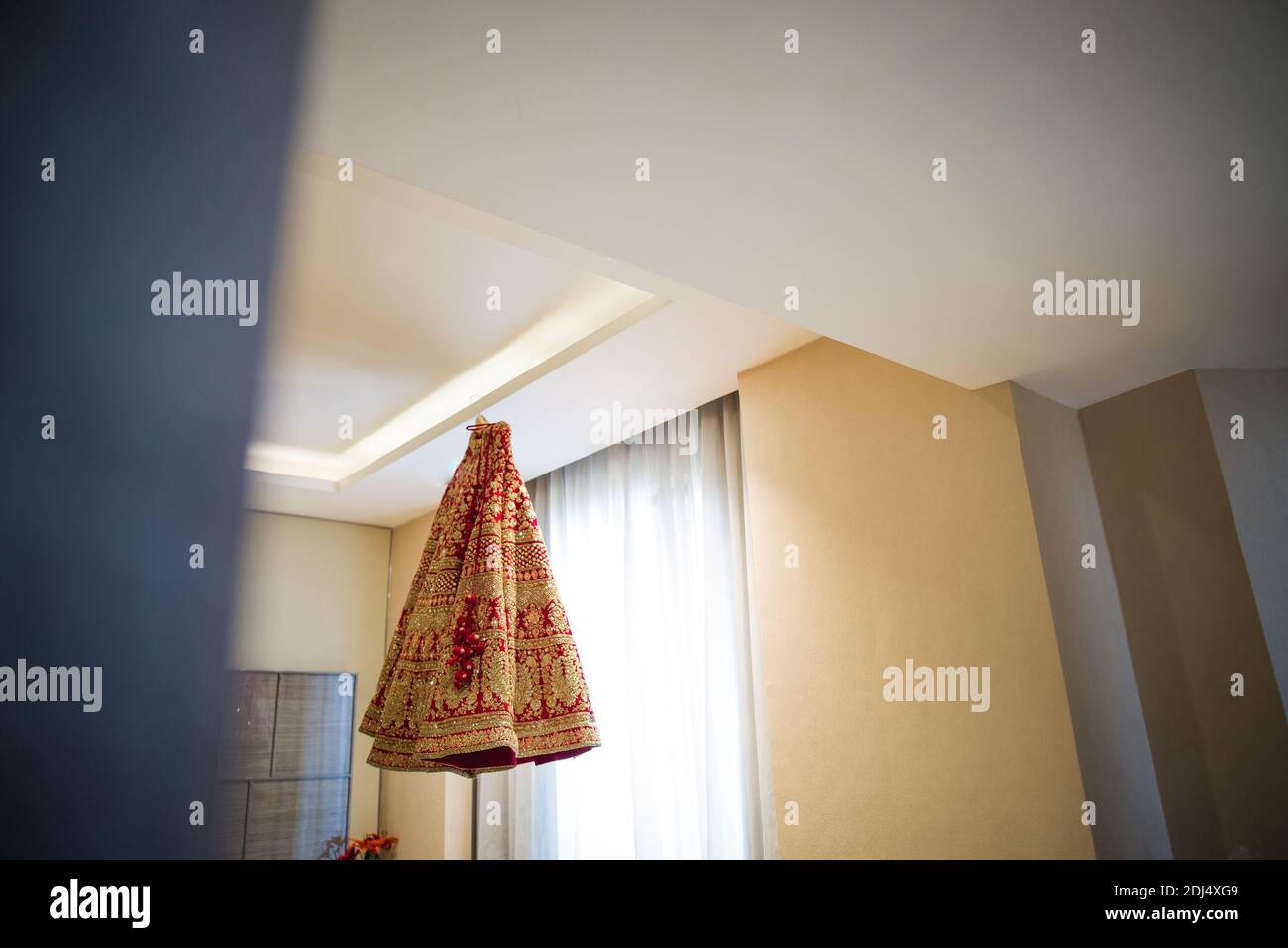 beautiful wedding dress of indian bride hanging from roof Stock Photo