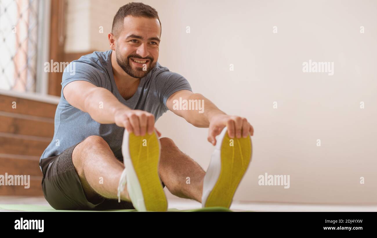 Athletic Man Doing Seated Adductor Stretch at Home Stock Photo - Image of  sporty, active: 65371528